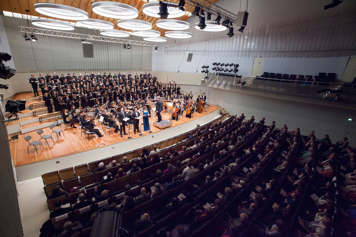 Blick von der Empore auf Chor, Orchester und Publikum in einem modernen Konzertsaal