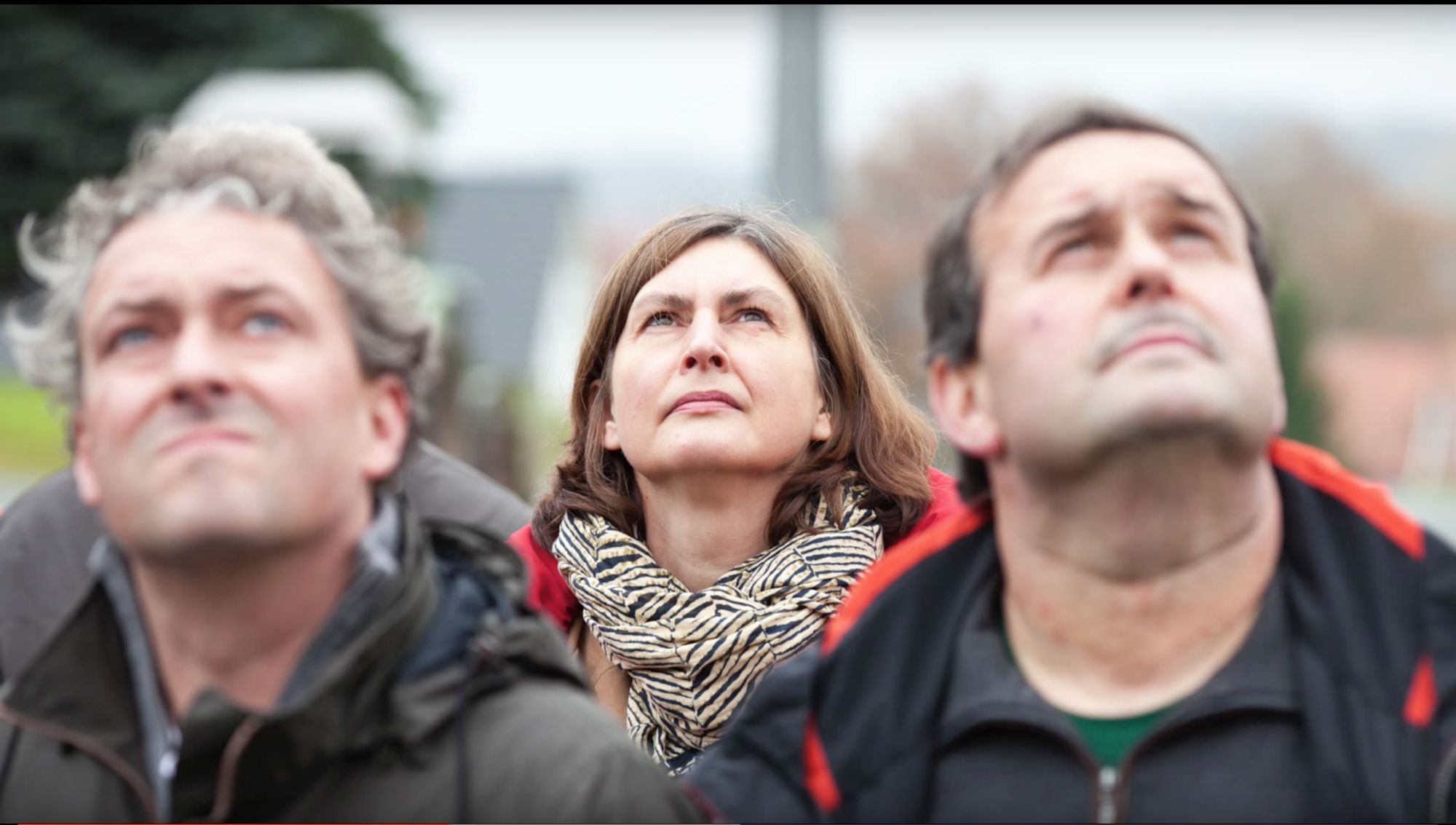 Nahaufnahme dreier Personen, die konzentriert in den Himmel blicken