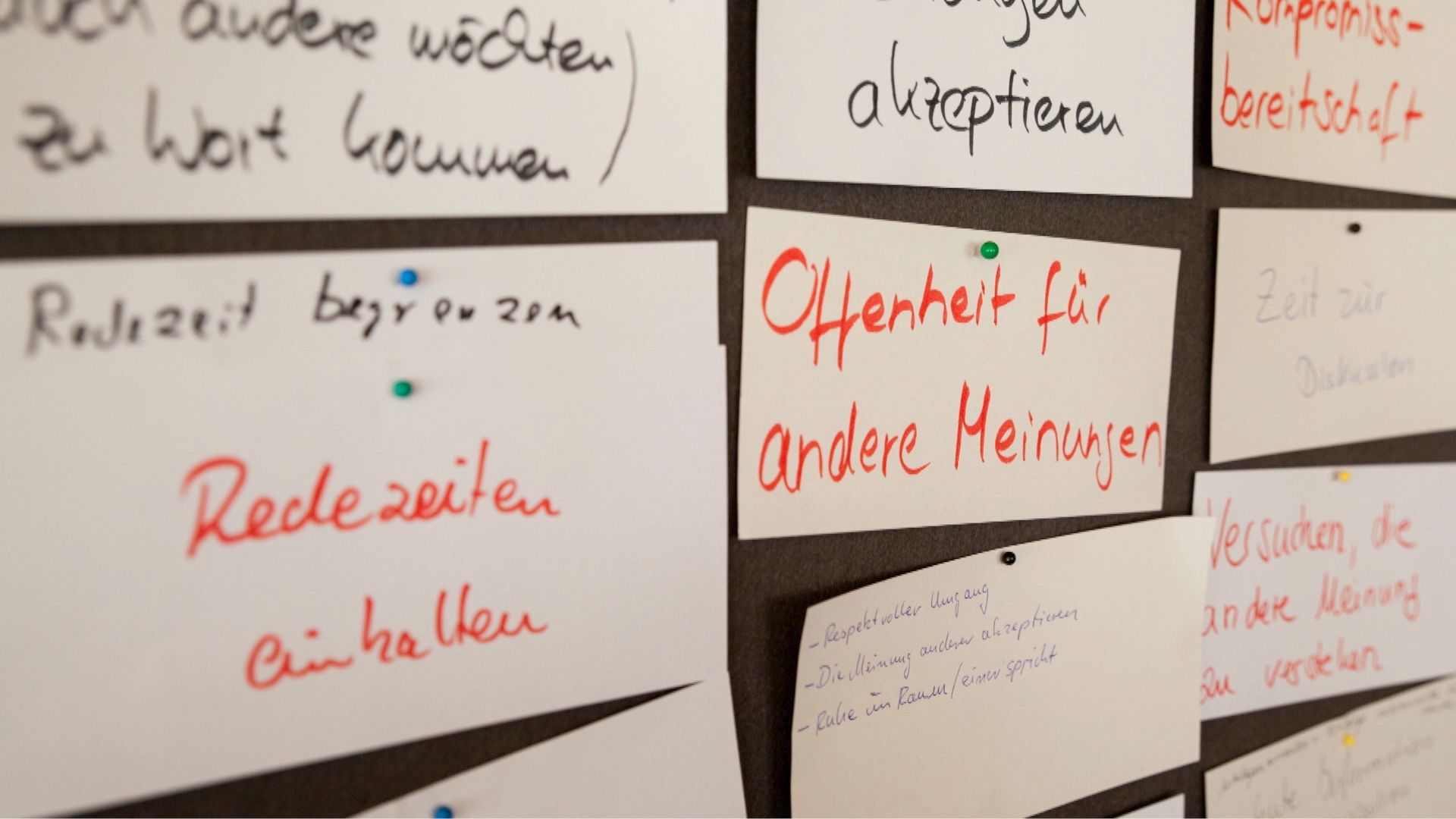 Handgeschriebene Moderationskarten mit Diskussionsregeln wie „Offenheit für andere Meinungen“