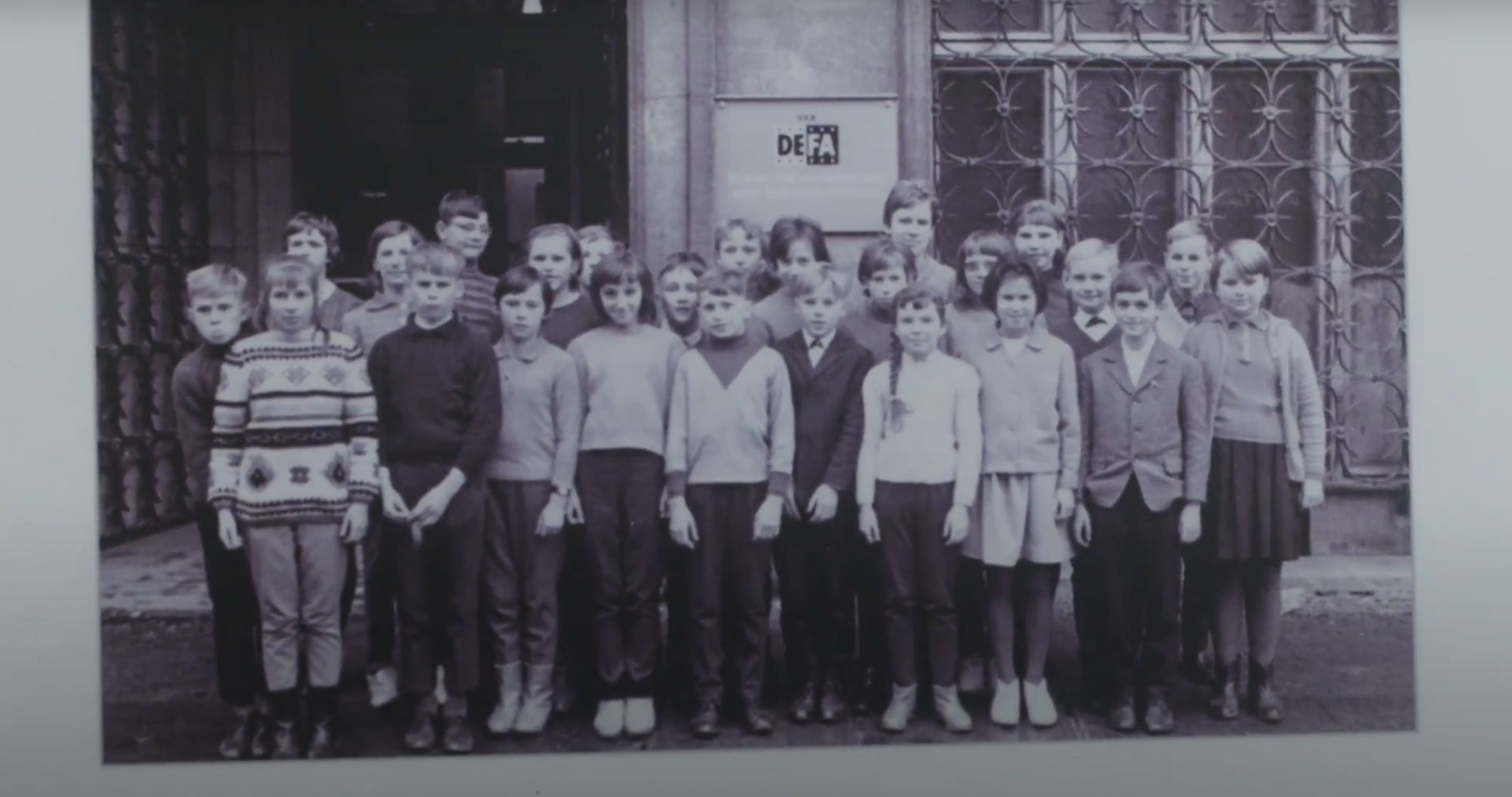 Historisches Gruppenfoto von Jugendlichen vor dem Eingang des DEFA-Studios