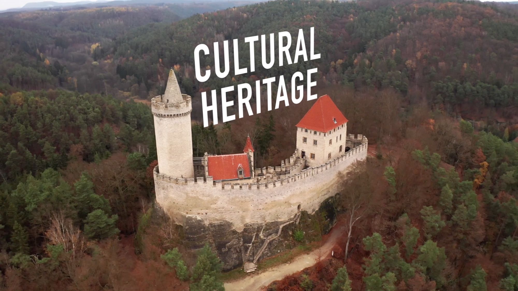 Luftaufnahme einer Burg auf Felsvorsprung mit Schriftzug „Cultural Heritage“