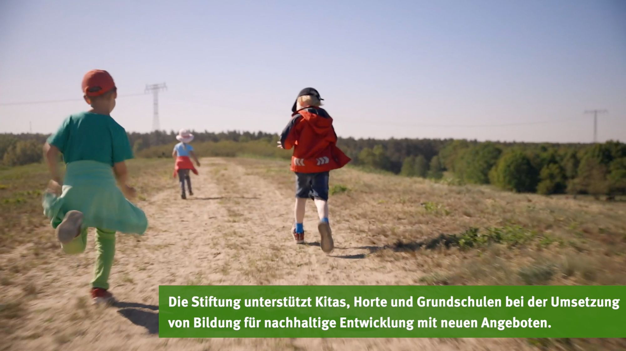 Kinder rennen über einen Feldweg an einem sonnigen Tag